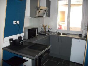 a small kitchen with a sink and a microwave at Les Mouettes in Le Tréport