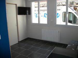 a living room with a tiled floor and windows at Les Mouettes in Le Tréport