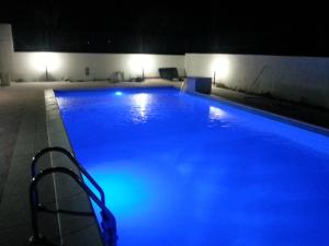 a large swimming pool with blue lighting in a building at Casa Vacanze Fontane Bianche in Fontane Bianche