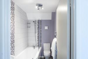 a bathroom with a tub and a toilet and a sink at Lulworth Lodge in Lulworth Cove +37 photos