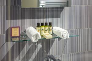 a glass shelf with oils and towels on a wall at Lulworth Lodge in Lulworth Cove
