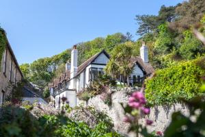 a house on the side of a hill with flowers at Lulworth Lodge in Lulworth Cove