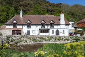 a large white house with a roof at Lulworth Lodge in Lulworth Cove