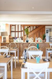a dining room with white tables and white chairs at Lulworth Lodge in Lulworth Cove