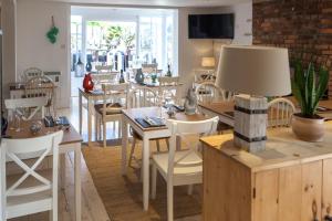 a dining room with tables and chairs and a lamp at Lulworth Lodge in Lulworth Cove