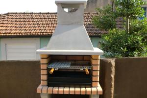 a barbecue oven sitting on top of a fence at The Yellow House in Vila Nova de Gaia