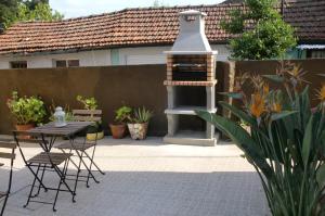 a patio with a grill and a table and chairs at The Yellow House in Vila Nova de Gaia