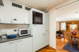 a kitchen with white cabinets and a microwave at Very central apartment in historical 1600 Palace with lift within a few min walk from San Marco Square in Venice