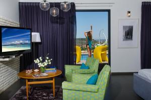 Kefar Weradim的住宿－The Fifties suites，客厅配有电视、2把椅子和1张桌子