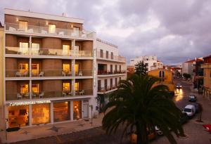 a building with a palm tree in front of it at Hotel Concha in São Martinho do Porto