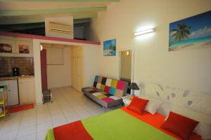 une chambre avec un lit et un canapé dans une pièce dans l'établissement Au Domaine Des Bougainvilliers, à Sainte-Rose