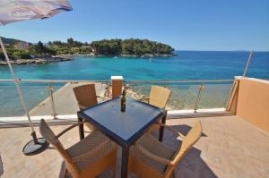 a table and chairs on a balcony with a view of the ocean at Riva1 Apartments and Rooms in Prizba