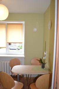 a dining room with a table and chairs and a window at "Jūrmala" in Liepāja