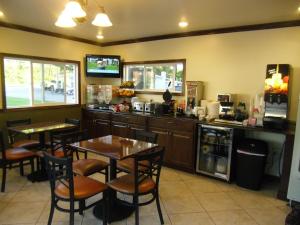 a restaurant with tables and chairs and a kitchen at Pilgrim Inn & Cottages in Plymouth