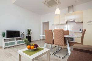 a kitchen and living room with a bowl of fruit on a table at Apartmani Ujakovic in Kaštela