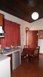 a kitchen with a table and a red curtain at Hotel Cacique Adiact in León