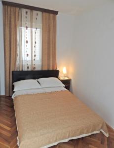 A bed or beds in a room at Apartman Husic
