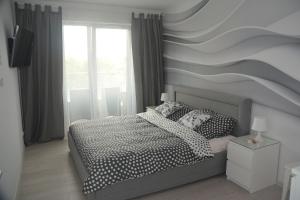 a bedroom with a bed with a wave painted on the wall at Apartament Solna 11 in Kołobrzeg