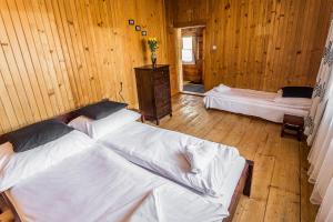ザコパネにあるDomek Potocekの木製の部屋にベッド2台が備わるベッドルーム1室