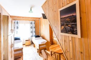a small room with two beds and a table at Domek Potocek in Zakopane