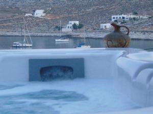 a bath tub filled with water next to a body of water at AMO Folegandros in Karavostasi