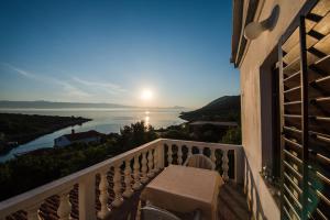 a balcony with a table and a view of the water at Apartmani Marko in Gdinj
