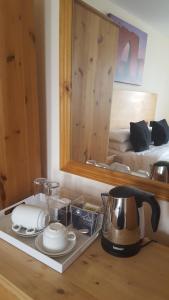 a tray with a tea kettle and dishes on a table at Franklyn Guesthouse in Saint Helier Jersey