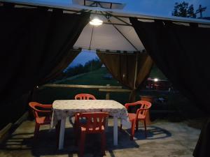 a table with chairs and an umbrella in a tent at Casa Chamonin in Gressan