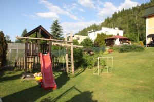 un parque infantil en un patio con tobogán en Villa Anastazis - Penzion Eden, en Karlovy Vary