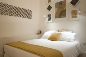 - une chambre avec un grand lit blanc et des oreillers blancs dans l'établissement Zelije Apartments Trindade, à Porto