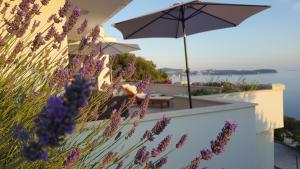 a patio with purple flowers and an umbrella at Apartment Infinity Blue in Mlini