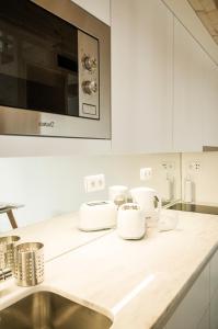 ポルトにあるZelije Apartments Trindadeの白いキャビネットとシンク付きのキッチン