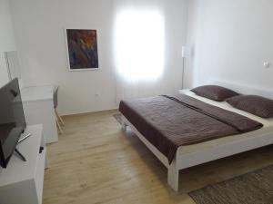 a bedroom with a bed and a flat screen tv at Apartments Lavanda in Vinišće