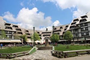 a large building with a fountain in front of it at Apartments Mozaik in Kopaonik