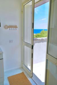 a door to a balcony with a view of the ocean at Villa Alba in Acitrezza