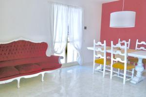 a living room with a red couch and a table at Villa Alba in Acitrezza