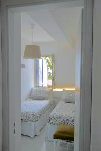 a white room with two beds and a mirror at Villa Alba in Acitrezza
