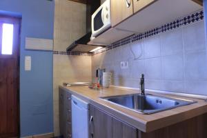 a kitchen with a sink and a counter at Apartamentos La Picota in Cofiñal +27 photos