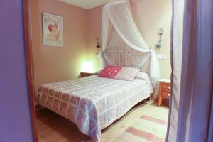 a small bedroom with a bed with a canopy at Apartamentos La Picota in Cofiñal