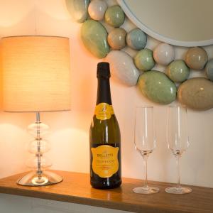 a bottle of wine sitting on a table with two glasses at Ellerbrook House in Windermere