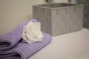 a purple towel with a white flower on it at Apartmani Ujakovic in Kaštela +45 photos