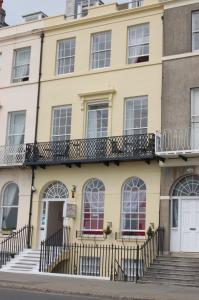 a yellow building with a balcony at The Edenhurst Guesthouse in Weymouth