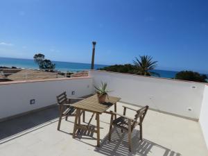 a table and chairs on a balcony with the ocean at casa verdemare in Cefalù