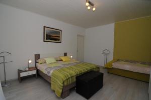a bedroom with a bed and a ottoman in it at Apartment Duka in Krk
