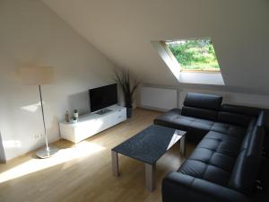ein Wohnzimmer mit einem Sofa und einem TV in der Unterkunft Ferienwohnungen am Fohrenberg in Meersburg