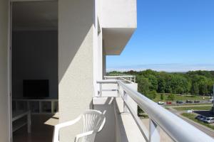 a white chair sitting on the balcony of a building at Sea Apartment in Gdańsk