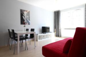 a living room with a table and a red couch at Sea Apartment in Gdańsk