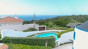 a house with a swimming pool and the ocean at O Moinho da Roca in Azoia