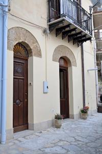 a building with a wooden door and a balcony at Alcova di relax in Castellammare del Golfo