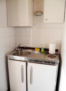 małą kuchnię ze zlewem i kuchenką w obiekcie Akis Apartments Kontogialos-Pelekas w mieście Pelekas +37 zdjęć
